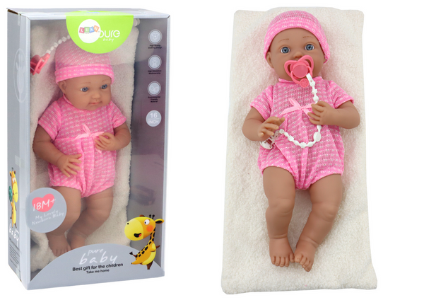 Baby doll in pink clothes, hat, pacifier, and blanket