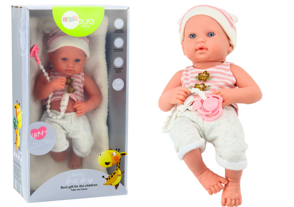 Baby doll in white and pink clothes, hat, pacifier, and blanket