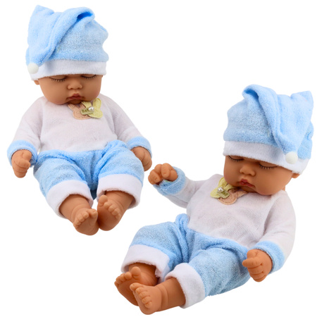 Schlafende Babypuppe in blauer Pyjamamütze mit Bommel