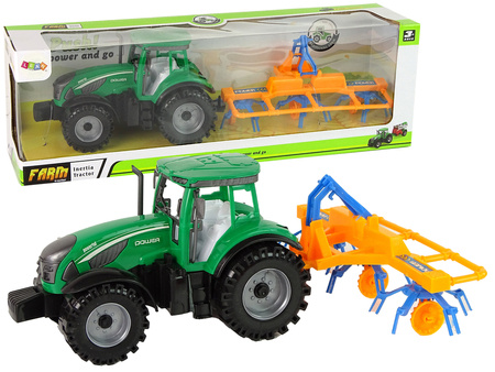 Grüner Traktor mit orangefarbener und blauer Harke Reibungsantrieb