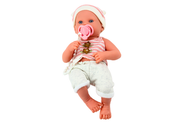 Baby doll in white and pink clothes, hat, pacifier, and blanket