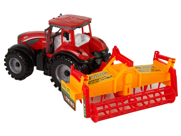 Roter Traktor mit orangefarbenem Grubberantrieb