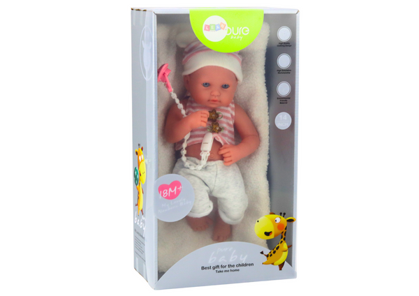 Baby doll in white and pink clothes, hat, pacifier, and blanket