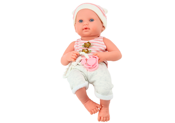 Baby doll in white and pink clothes, hat, pacifier, and blanket